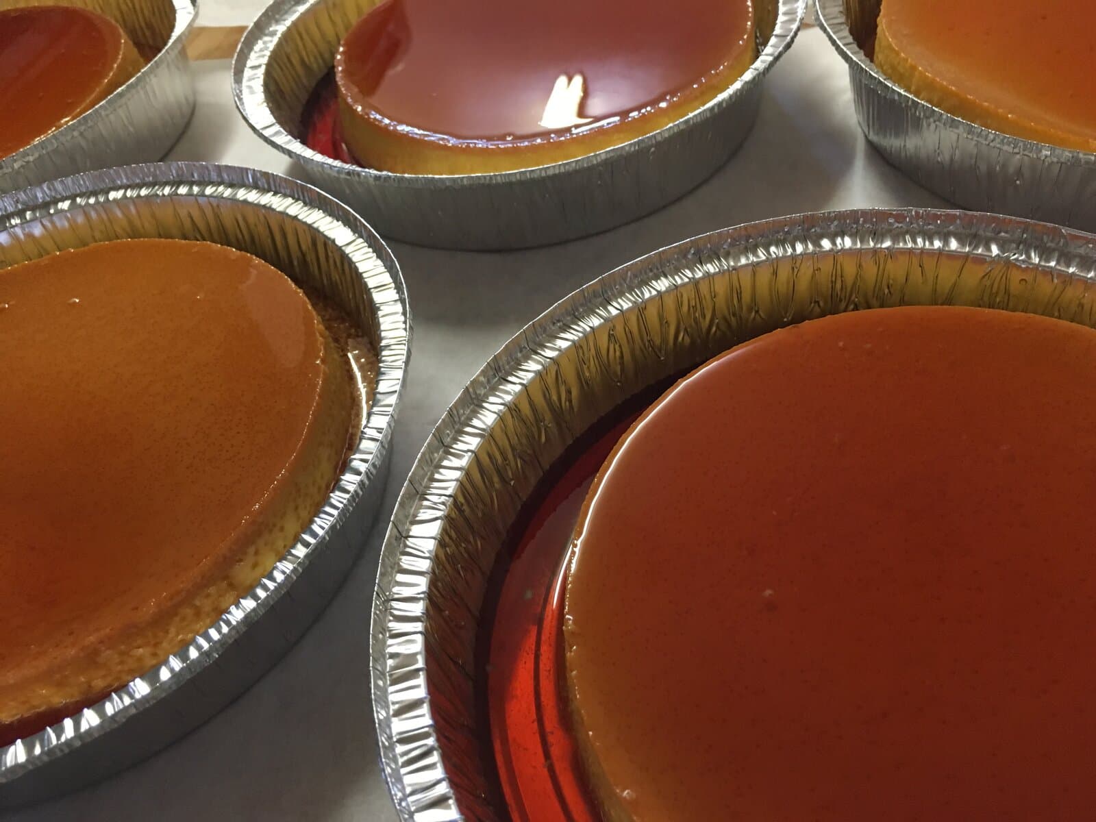 Flanes napolitanos individuales en moldes de aluminio con caramelo brillante en Tlaxcala Bakery